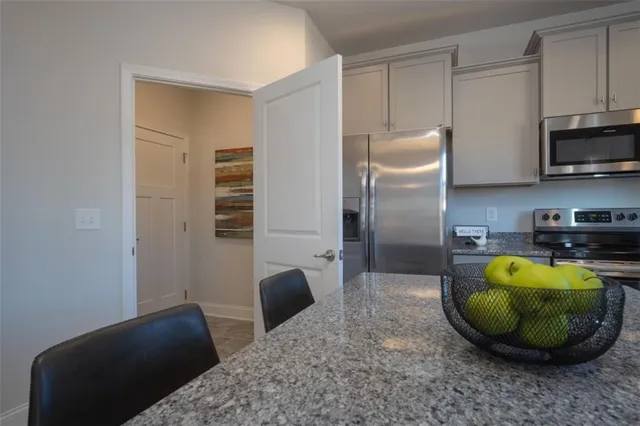 a view of kitchen with stainless steel appliances granite countertop a stove a sink and a refrigerator