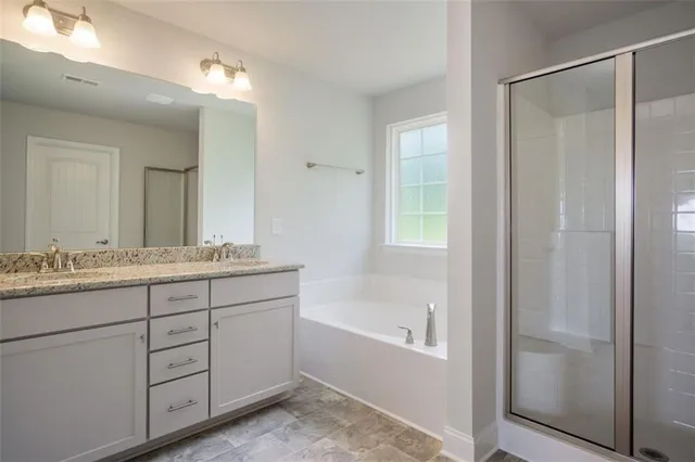 a bathroom with a granite countertop sink mirror and a bathtub