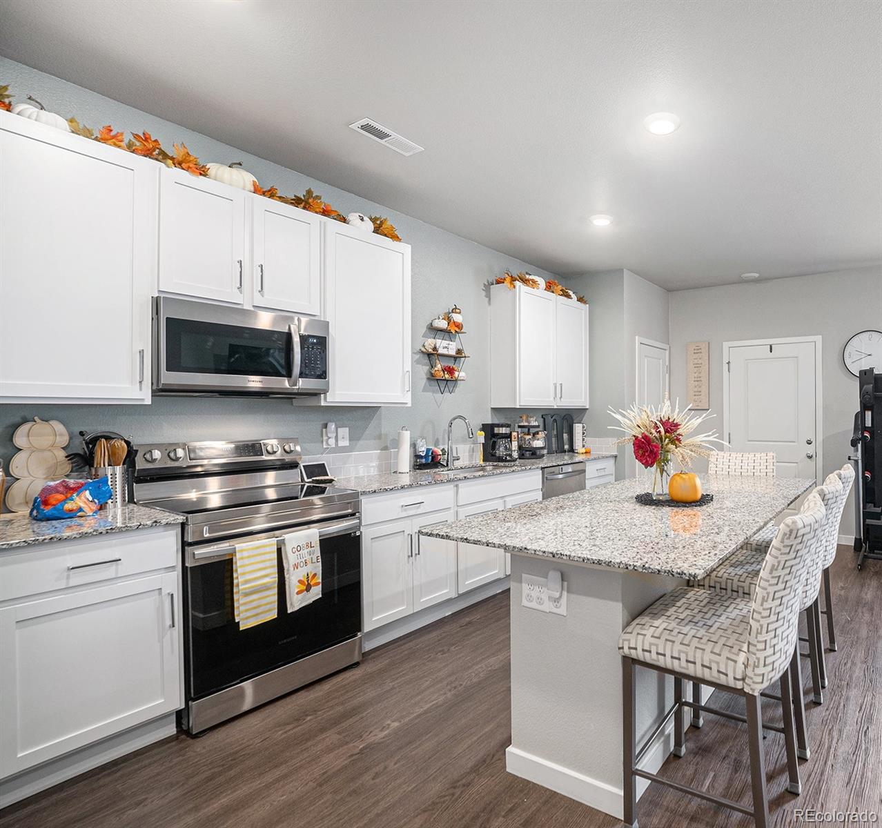 a kitchen with stainless steel appliances granite countertop a stove a sink dishwasher a microwave oven with a dining table and chairs