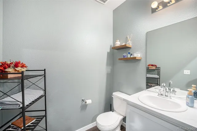 a bathroom with a sink vanity mirror and toilet