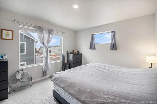 a bedroom with a bed and dresser with mirror