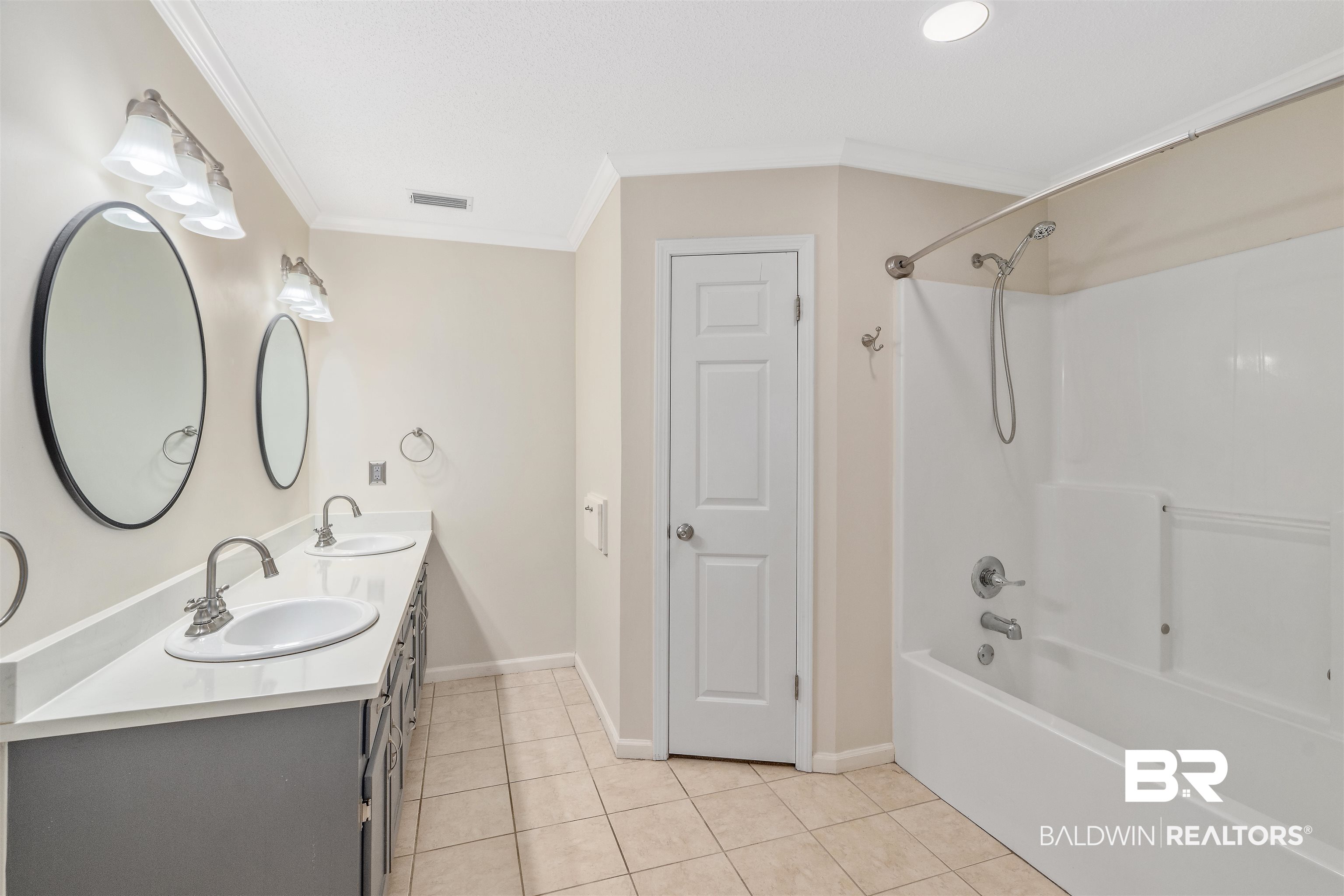 25779 Austin Road Daphne, AL 36526 - Photo 23 of 30 Bathroom with ornamental molding, double vanity, shower combination, tile patterned floors, and baseboards