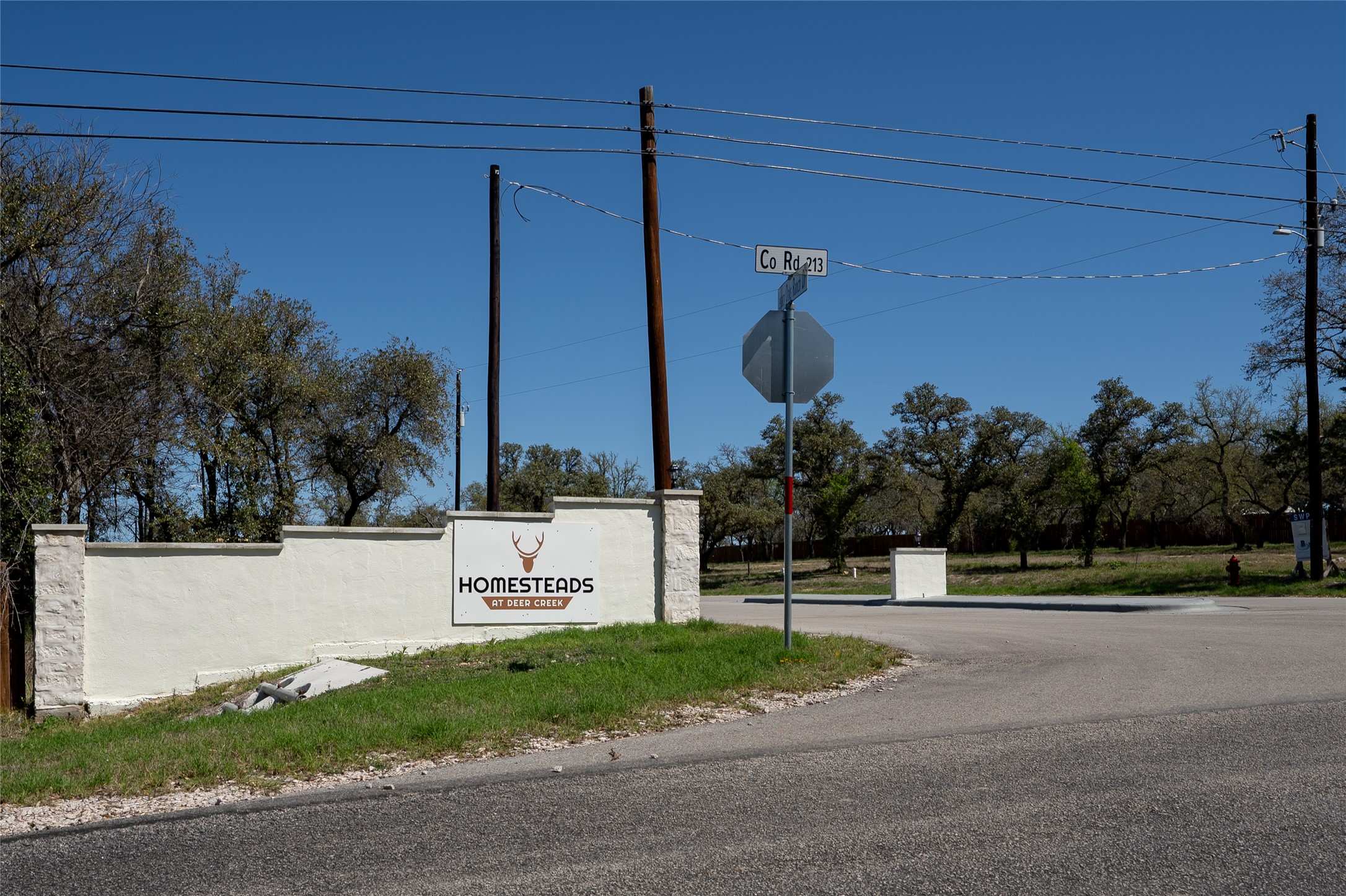 203 Sandy Oaks Ranch Road Johnson City, TX 78636 - Photo 2 of 10 a sign board with buildings in the background