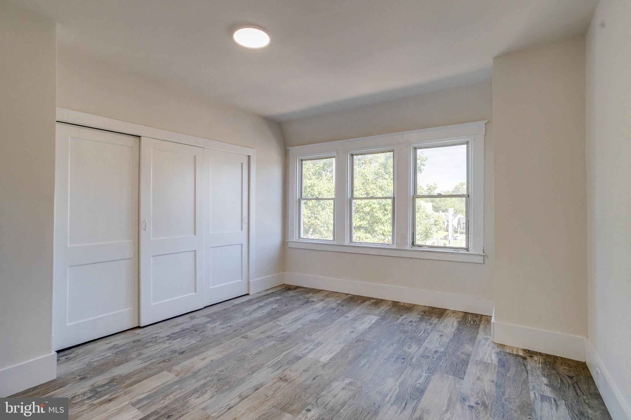 5878 Belair Road Baltimore, MD 21206 - Photo 18 of 41 an empty room with wooden floor and windows