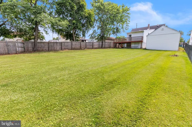 a view of a house with a big yard and large trees