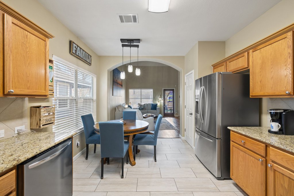 207 Rosedale Boulevard Georgetown, TX 78628 - Photo 31 of 31 a kitchen with stainless steel appliances granite countertop a refrigerator a sink dishwasher a dining table and chairs with wooden floor