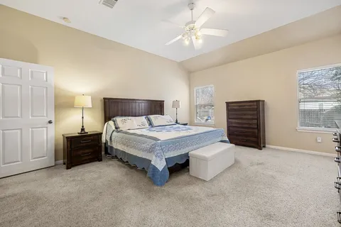 a spacious bedroom with a bed and a chandelier