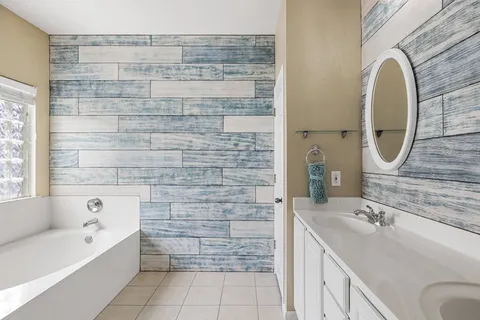 a bathroom with a sink mirror and a bathtub