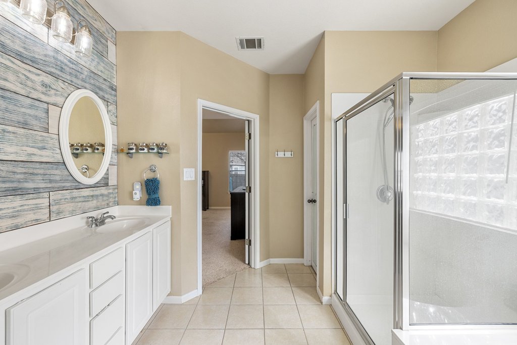 207 Rosedale Boulevard Georgetown, TX 78628 - Photo 17 of 31 a spacious bathroom with a double vanity sink a mirror and a shower