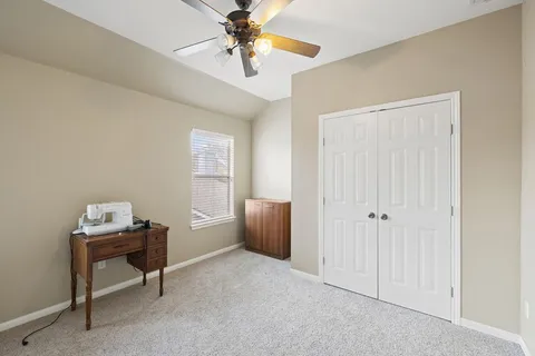 a view of a workspace with furniture and a window