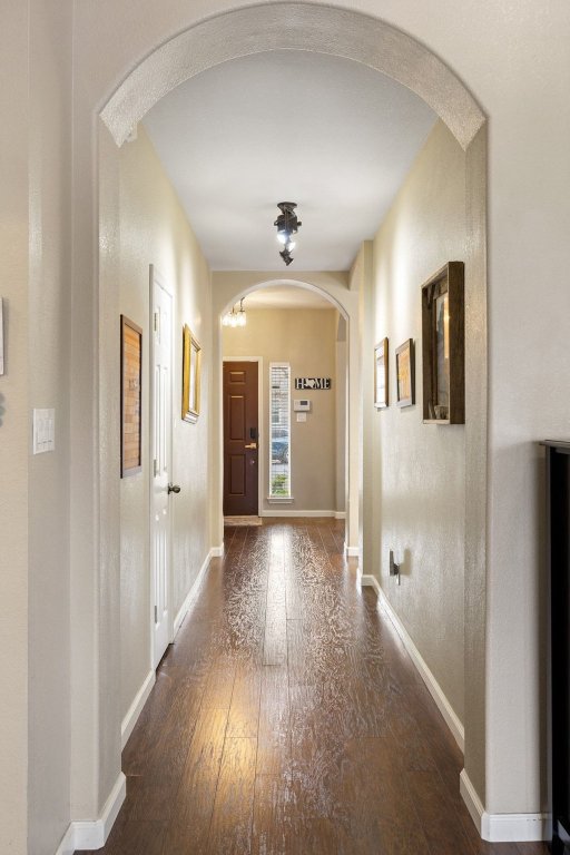 207 Rosedale Boulevard Georgetown, TX 78628 - Photo 7 of 30 Corridor with arched walkways and dark wood-style flooring