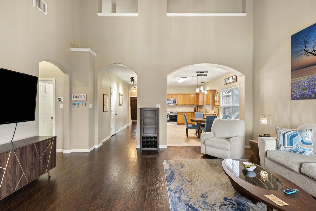 207 Rosedale Boulevard Georgetown, TX 78628 - Photo 9 of 30 Living room with arched walkways, dark wood-type flooring, and a high ceiling
