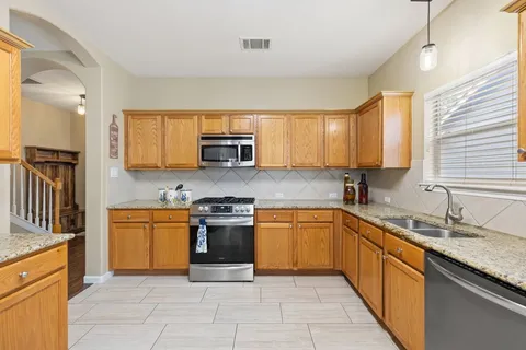 a kitchen with stainless steel appliances granite countertop a stove a sink and a microwave