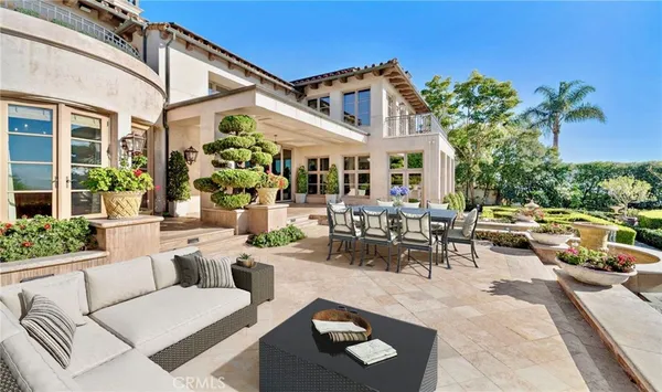 a view of a patio with couches table and chairs and potted plants