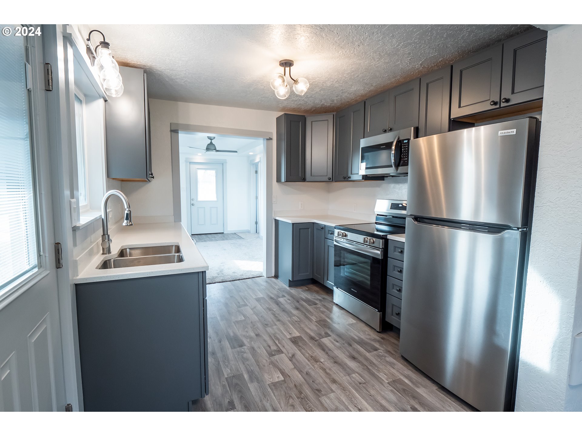 930 Elm Street Junction City, OR 97448 - Photo 3 of 33 a kitchen with granite countertop stainless steel appliances a refrigerator a sink and a stove