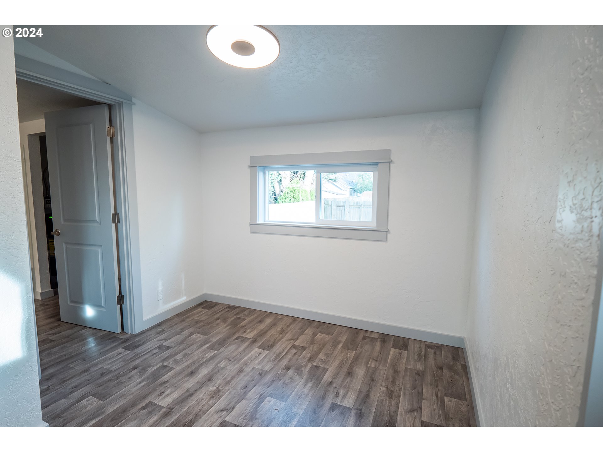 930 Elm Street Junction City, OR 97448 - Photo 7 of 33 a view of an empty room with wooden floor and a window