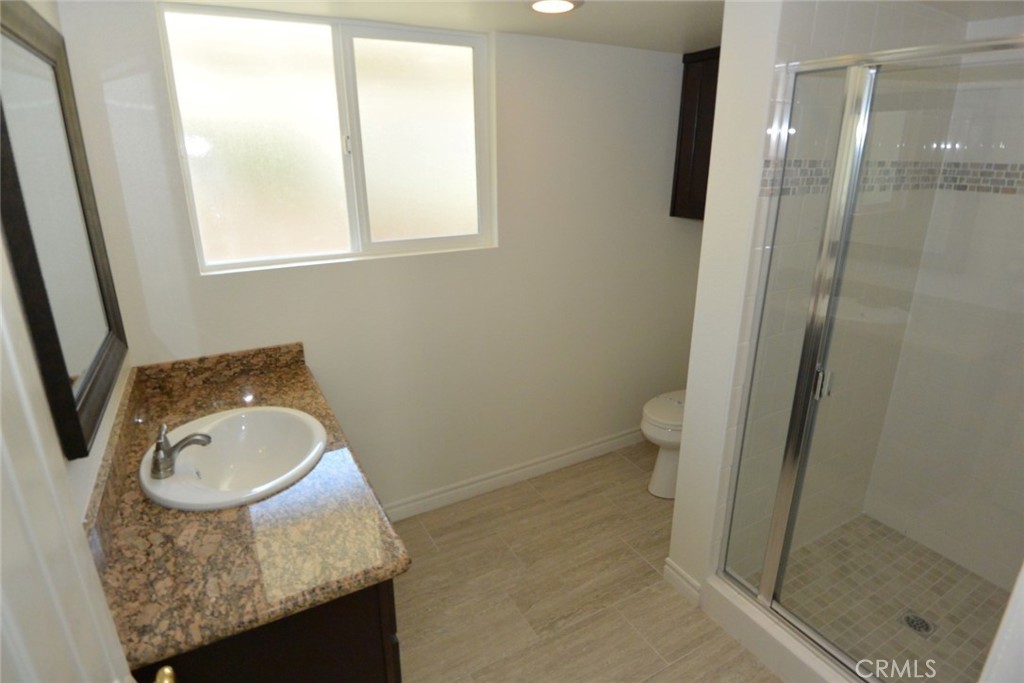 11392 Wallingsford Road Los Alamitos, CA 90720 - Photo 13 of 17 a bathroom with a granite countertop sink and a mirror