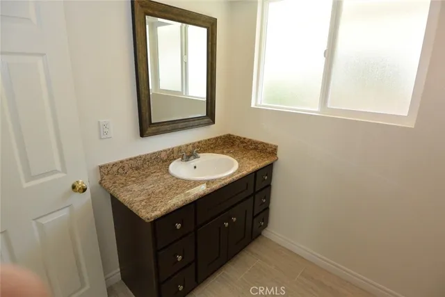 a bathroom with a granite countertop sink and a mirror