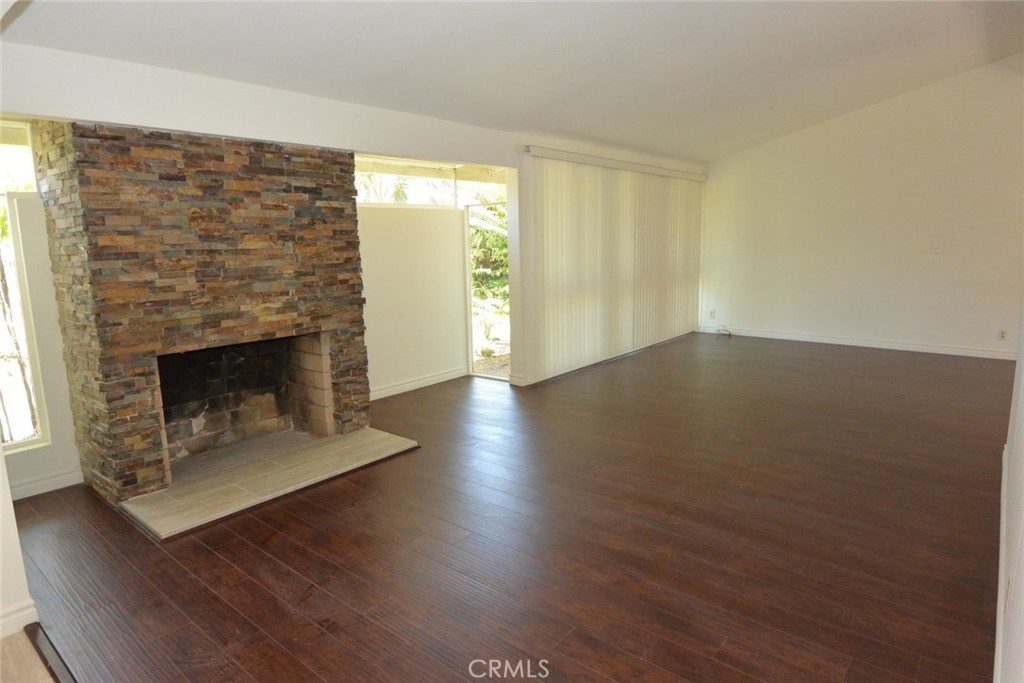 11392 Wallingsford Road Los Alamitos, CA 90720 - Photo 3 of 17 an empty room with wooden floor and fireplace