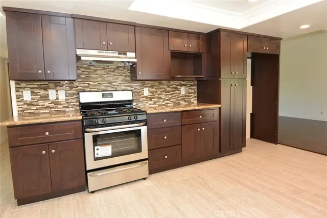 a kitchen with stainless steel appliances granite countertop a stove and a refrigerator