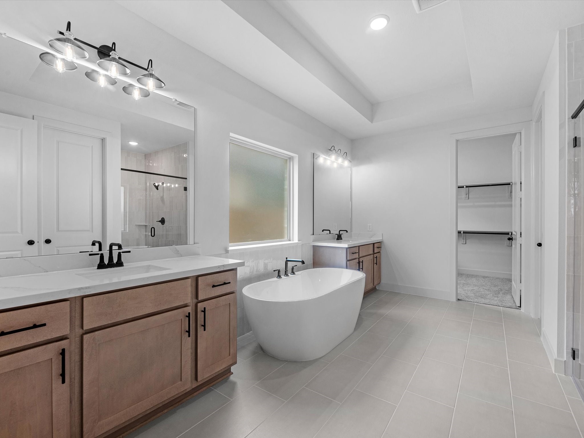 8915 Acropolis Lane Manvel, TX 77578 - Photo 14 of 32 a spacious bathroom with a double vanity sink mirror and bathtub