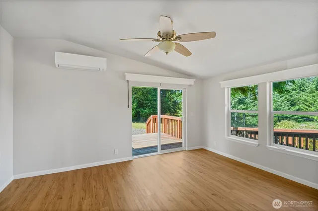 a view of a big room with wooden floor and windows