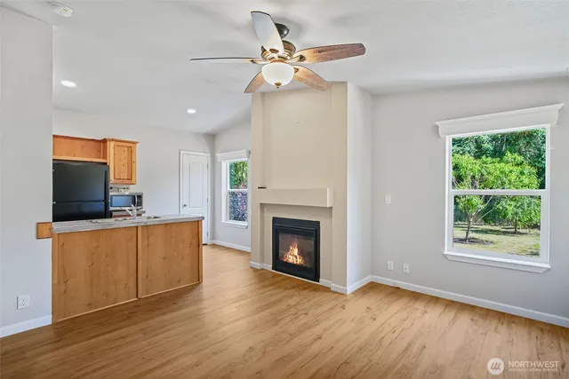 a view of an empty room with wooden floor and a fireplace