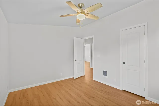 an empty room with window and wooden floor