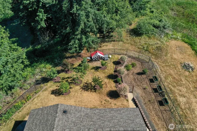a view of a house with pool plants and trees with wooden fence