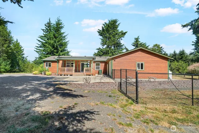 a view of a yard in front of a house with wooden fence