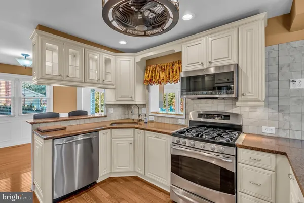 a kitchen with cabinets appliances a sink and a window