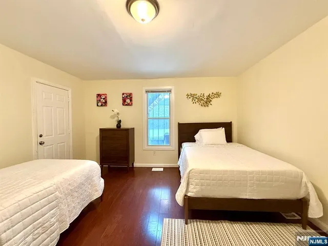 a bedroom with two beds and lamp