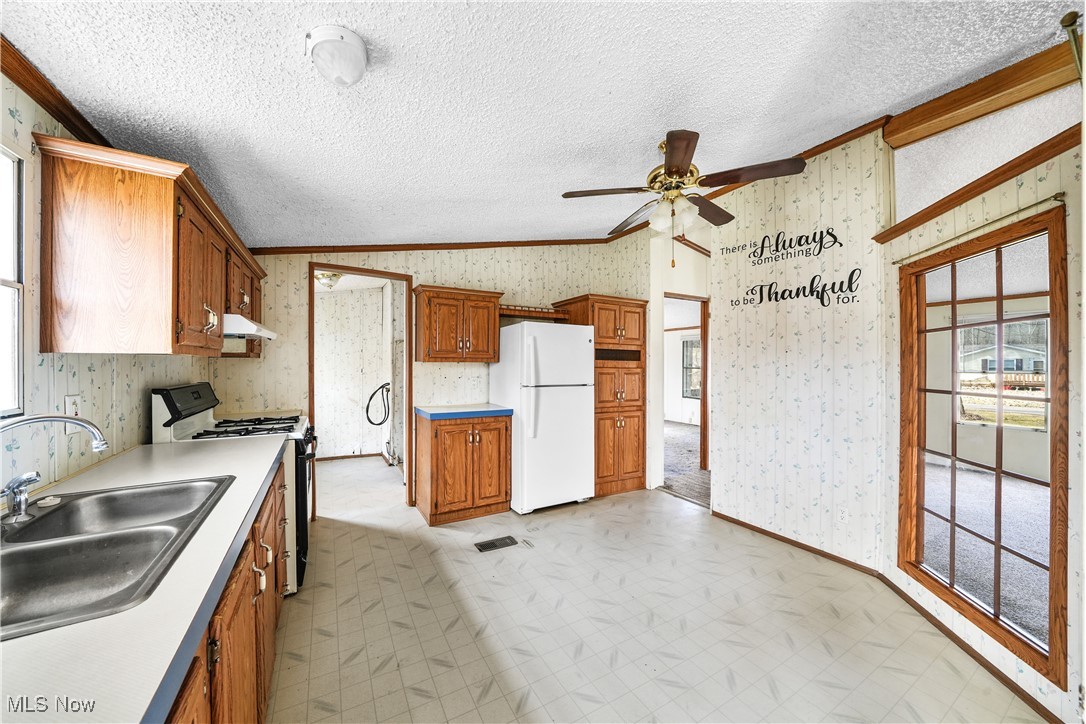 3792 Selnik Road Kent, OH 44240 - Photo 7 of 39 Kitchen featuring wallpapered walls, gas range, a sink, and freestanding refrigerator