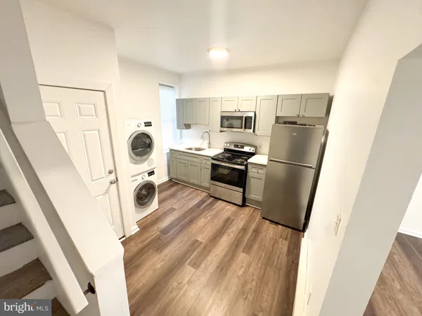 a kitchen with a refrigerator a stove top oven and a sink