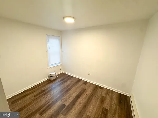 an empty room with a wooden floor and a window