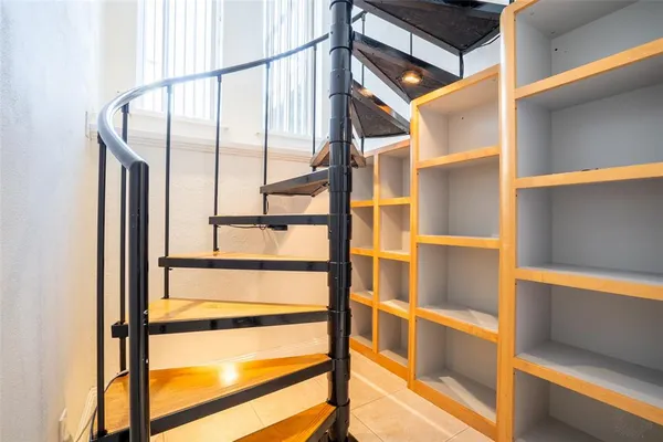 an empty room with wooden floor ceiling fan and window
