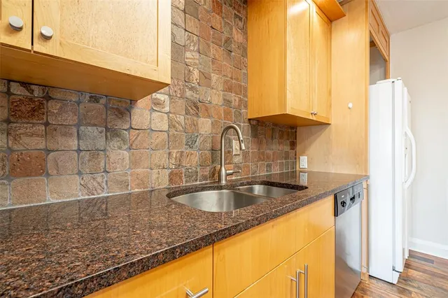 a kitchen with stainless steel appliances granite countertop a sink stove and refrigerator