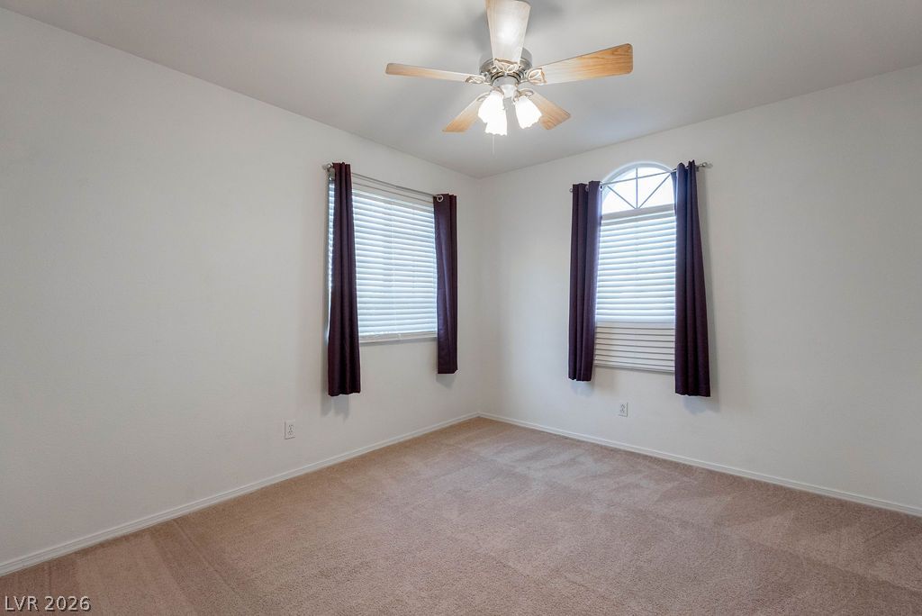 8379 Rockefeller Street Las Vegas, NV 89123 - Photo 32 of 36 Plush carpeting and multiple windows anchor this versatile secondary bedroom space.