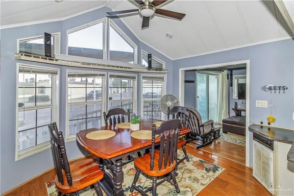 a dining room with furniture a chandelier and wooden floor