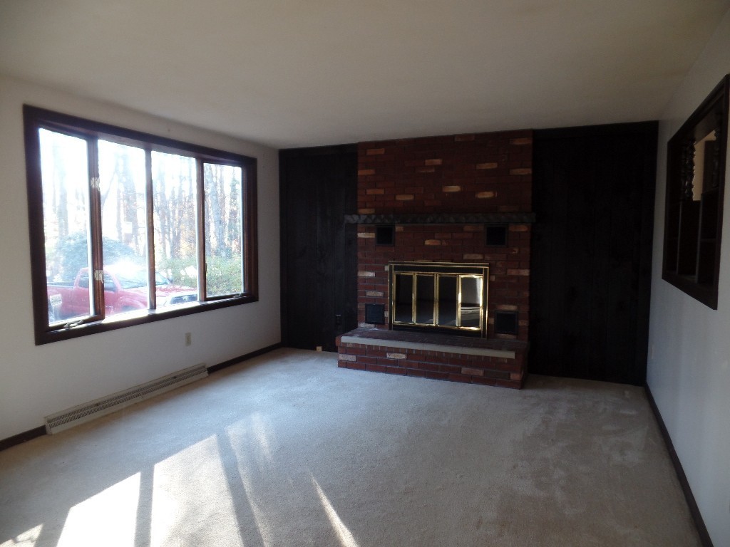 501 Walnut Plain Road Rochester, MA 02770 - Photo 2 of 8 a view of an empty room with a fireplace and a window