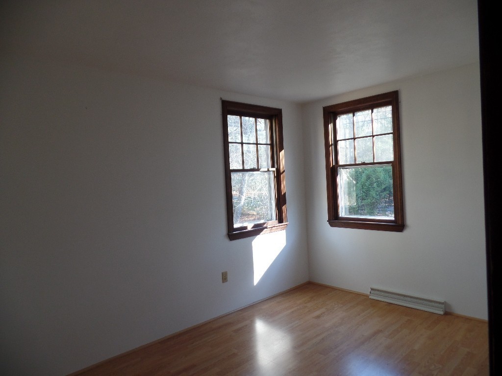 501 Walnut Plain Road Rochester, MA 02770 - Photo 7 of 8 an empty room with wooden floor and windows