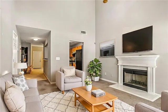 a living room with furniture a flat screen tv and a fireplace