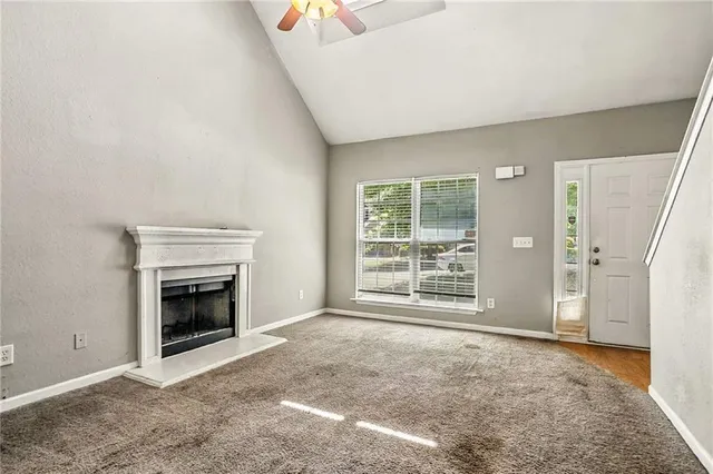 a view of an empty room with a fireplace and a window