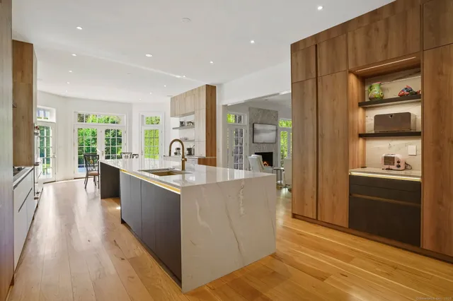 a large kitchen with kitchen island a large counter top space a sink stainless steel appliances and cabinets