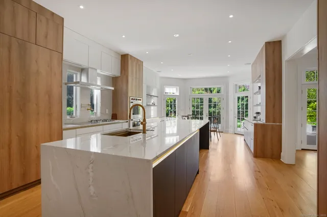 a kitchen with stainless steel appliances granite countertop a sink a stove and a refrigerator