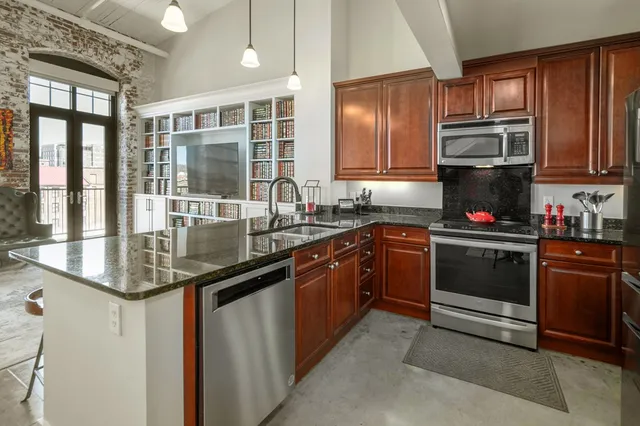 a kitchen with stainless steel appliances granite countertop a stove and a sink