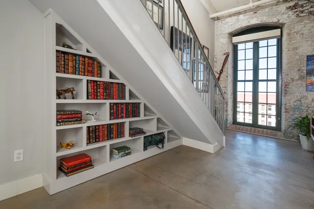 a room with lots of white walls and a book shelf