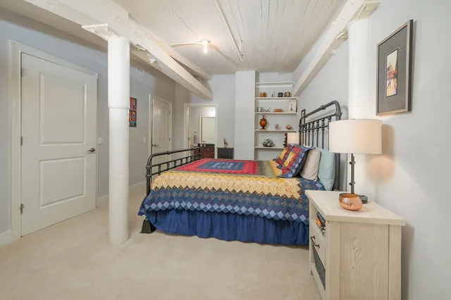 a bed sitting in a bedroom next to a lamp