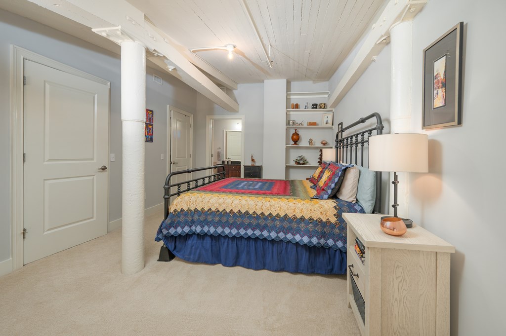 1201 Front Avenue, Unit 509 Columbus, GA 31901 - Photo 31 of 41 a bed sitting in a bedroom next to a lamp