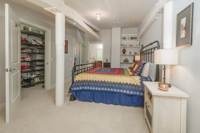 a bed sitting in a bedroom next to a lamp